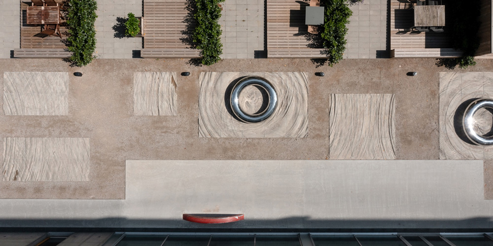 50-meter tapestry of undulating concrete tiles & steel lifebuoys invites reflection in denmark