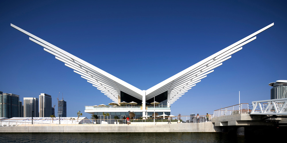 A curving steel finned roof extends over AMA`s dubai harbour yacht club