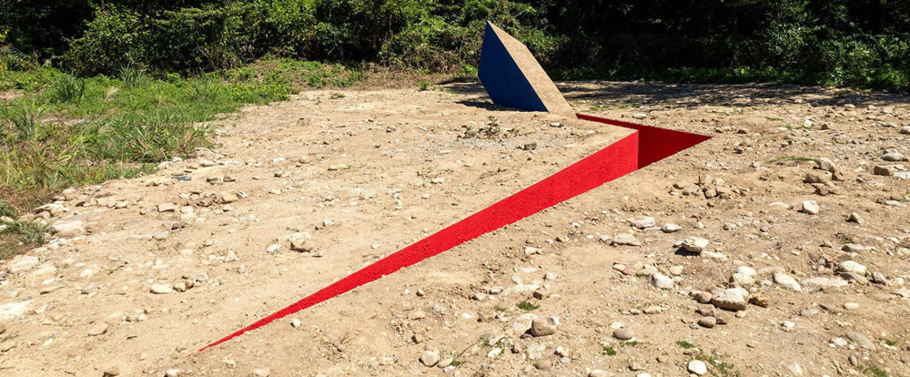 A slender red opening slices the earth for hajime yoshida architecture`s land art in japan