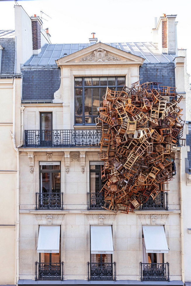Tadashi kawamata nests a tower of wooden chairs onto liaigre`s parisian mansion facade