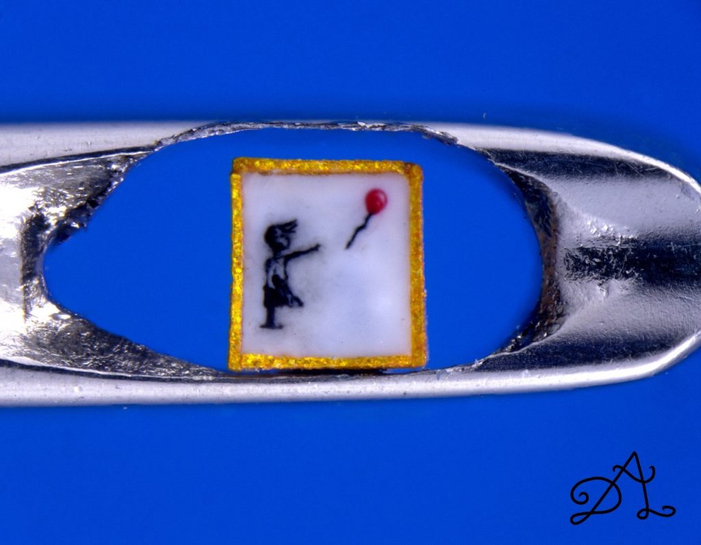 See a Microscopic Version of Banksy`s "Girl With a Balloon," So Tiny It Fits in the Eye of a Needle
